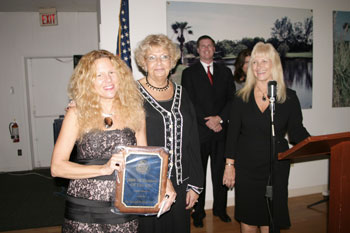Tide and Moon gift shop owner Laura Shely accepts the small business
of the year award from Chamber board member Ellen Aquilina, of Sun
Trust Bank.